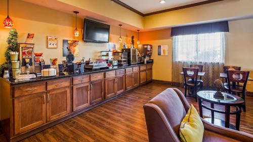 een bar met houten kasten en een televisie aan de muur bij Best Western Plus Seminole Hotel & Suites in Seminole