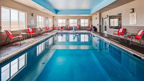 una gran piscina con sillas y mesas rojas en Best Western Plus Tech Medical Center Inn en Lubbock