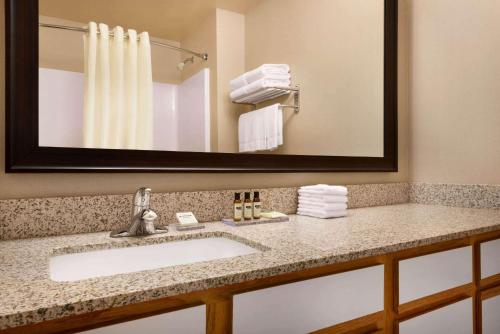 a bathroom with a sink and a mirror at Hawthorn Suites By Wyndham Oak Creek/Milwaukee Airport in Milwaukee