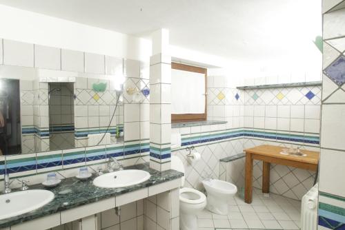 a bathroom with two sinks and a toilet at Podere Il Tigliolo in Castiglione dʼOrcia