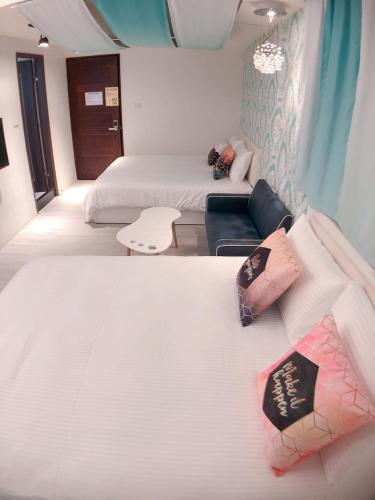 a hotel room with two beds and a couch at Traveler Station R15 in Kaohsiung