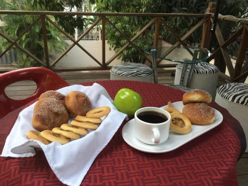 a table with a plate of pastries and a cup of coffee at G y V Hotels in Tegucigalpa