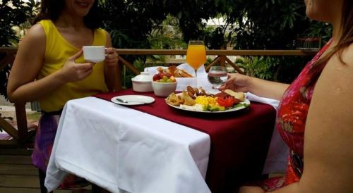two women sitting at a table with a plate of food at G y V Hotels in Tegucigalpa