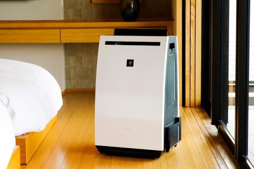 a white refrigerator sitting on the floor next to a bed at Umino Ryotei Okinawa Nakamasou in Onna