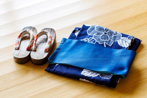 a pair of sandals and a bag on the floor at Umino Ryotei Okinawa Nakamasou in Onna