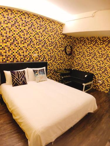 a bedroom with a large white bed and a chair at Traveler Station R15 in Kaohsiung