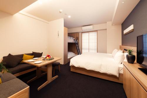 a bedroom with a bed and a couch and a tv at MIMARU Tokyo Hatchobori in Tokyo
