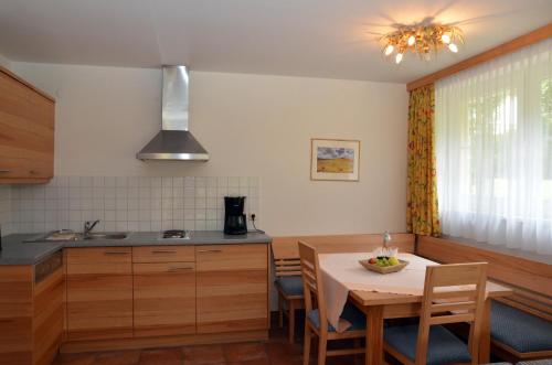 a kitchen with a table and a dining room at Hotel Rauscher - Das Naturteichparadies in Bad Hofgastein