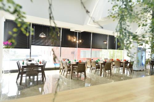 a dining room with tables and chairs and windows at Gwangju Tourist Hotel in Gwangju