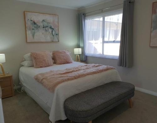 um quarto com uma cama grande e uma janela em Rose Apartments Unit 5 Central Rotorua- Accommodation & Spa em Rotorua