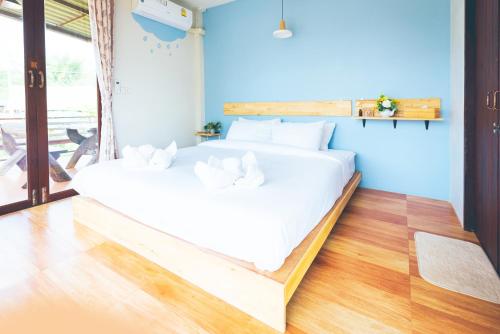 un grande letto bianco in una stanza con pareti blu di Wang Jai Kwang Space Inn a Chongsadao