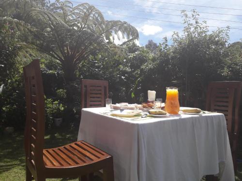 een tafel met een wit tafelkleed en twee stoelen bij Srihelyes Inn in Nuwara Eliya