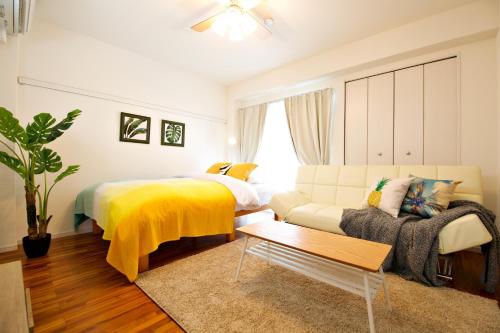 a living room with a bed and a couch at Matsufuji 2F in Naha