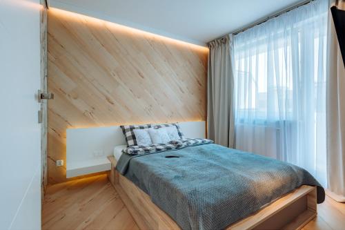 een slaapkamer met een groot bed met een houten hoofdeinde bij Apartament Scandi - Bliżej Morza in Kołobrzeg