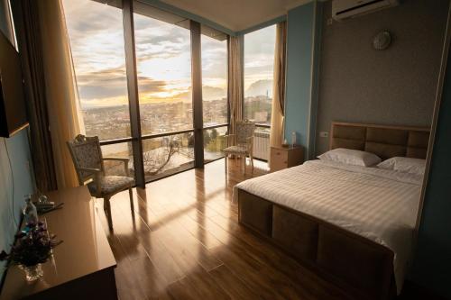 a bedroom with a bed and a large window at Nork Hotel in Yerevan
