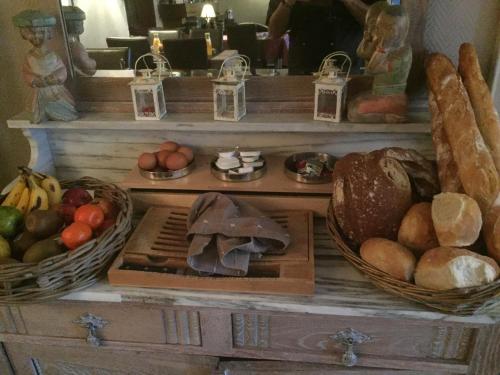 a table with baskets of fruits and vegetables on it at Auberge Le Relais in Corbion