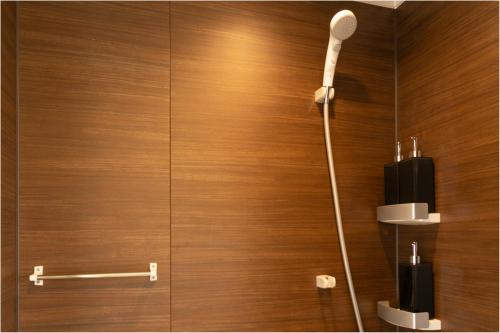 a shower in a bathroom with a wooden wall at Sakura Stay Yoga 201 in Tokyo