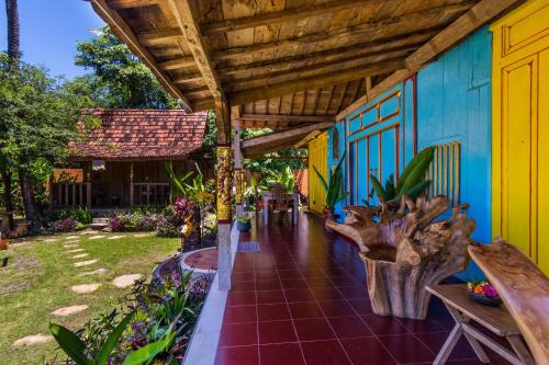 a patio of a house with a wooden roof at Villa Melasti Amed in Amed