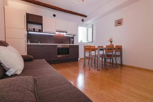 ein Wohnzimmer mit Sofa und Tisch und eine Küche in der Unterkunft Apartment Tranquillo in Piran