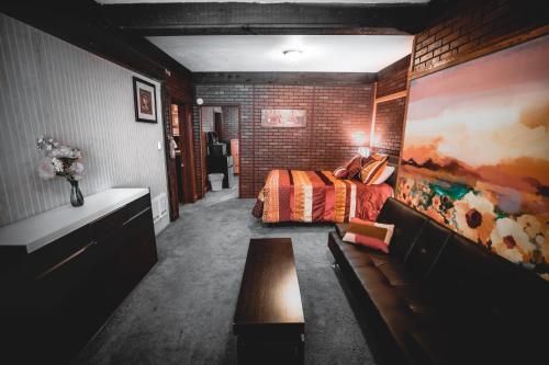 a bedroom with a bed and a brick wall at Gateway Inn & Cabins in Ashford