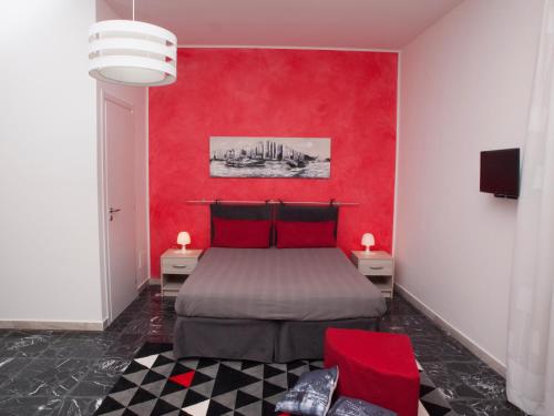 a red bedroom with a bed and a red wall at Bouganville House in Zafferana Etnea