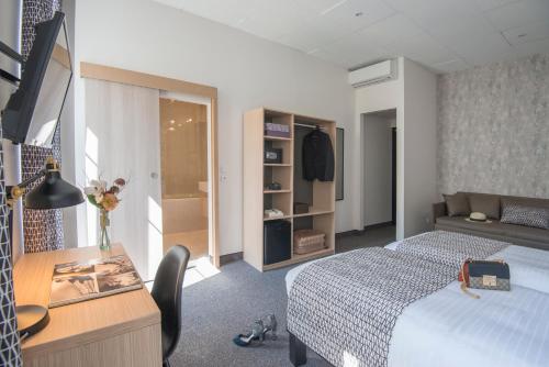 a hotel room with a bed and a desk and a bed and a room at Hotel Saint Gothard in Nice