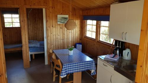 una pequeña cocina con mesa y una habitación con cama en Helsingør Camping & Cottages Grønnehave, en Helsingør