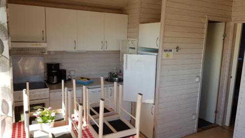 a small kitchen with white cabinets and a refrigerator at Helsingør Camping & Cottages Grønnehave in Helsingør