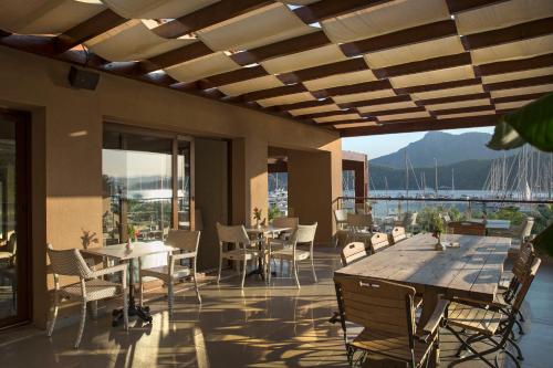 a patio with tables and chairs and a view of the water at Marti Hemithea Hotel in Orhaniye