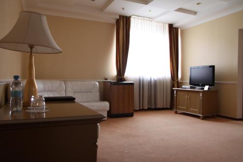a living room with a couch and a television at Отель Фараон in Kyiv