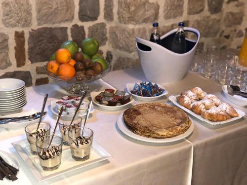 a table topped with a table with food and desserts at Hotel Monte Cristo in Kotor