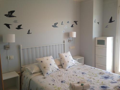 a bedroom with a bed with butterflies on the wall at Apartamentos Noluna in Segovia