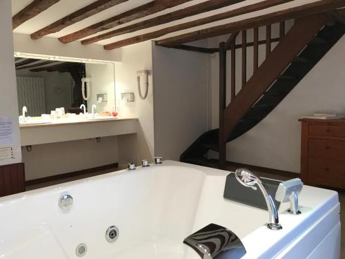 a bath tub with a sink and a mirror at Château de Sissi in Sassetot-le-Mauconduit