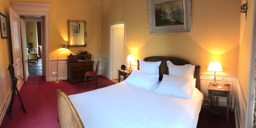 a bedroom with a bed with white sheets and pillows at Château de Sissi in Sassetot-le-Mauconduit