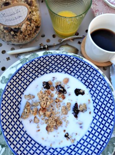 Een blauw-wit bord met ontbijtgranen op een tafel met een kop koffie. bij Manoir de Penn Lann in Paimpol