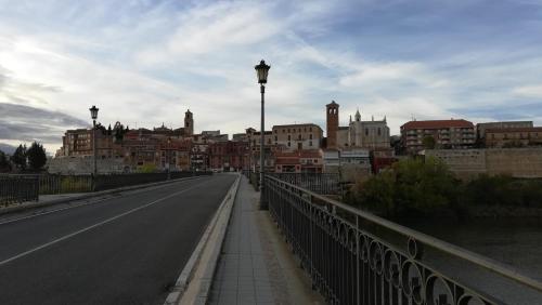 a bridge over a road in a city with buildings at La casa del Duero in Tordesillas