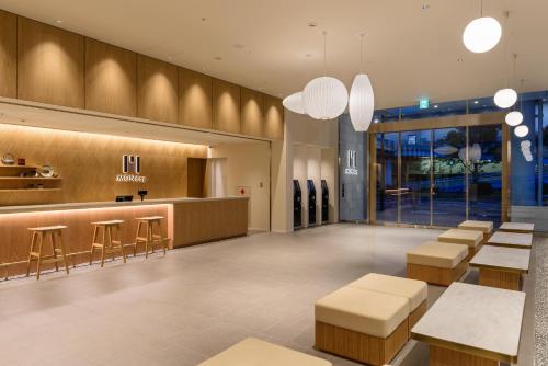a lobby of a store with tables and stools at hotel MONday Premium TOYOSU in Tokyo