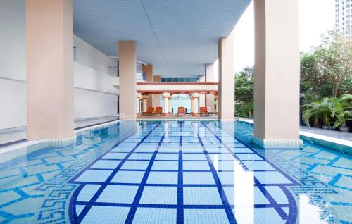 uma piscina com piso de azulejo azul num edifício em Silka Maytower Kuala Lumpur em Kuala Lumpur