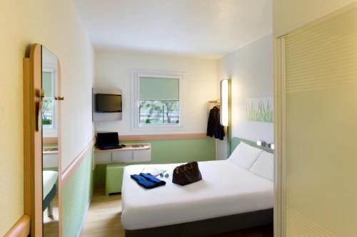 a hotel room with a white bed and a window at ibis budget Alicante in Alicante