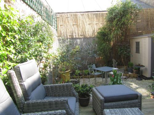 敦刻爾克的住宿－Chez Marie，庭院配有藤椅、桌子和桌子