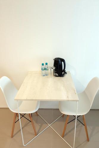 a table with two chairs and a coffee maker on it at The Rooms Apartment Bali by ARM Hospitality in Denpasar