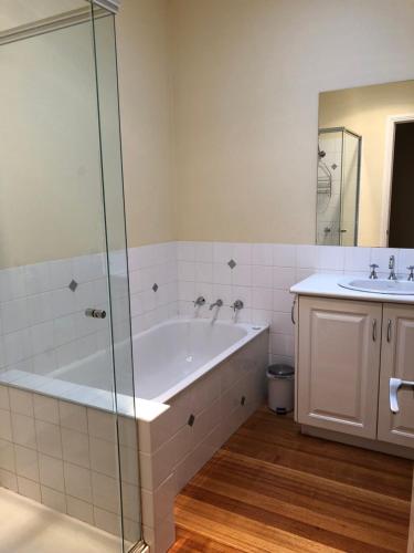 a bathroom with a tub and a sink at Seagrape Cottage in Ocean Grove