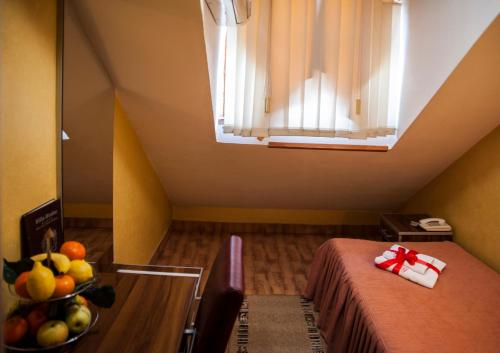 Cette chambre comprend un lit et une corbeille de fruits sur une table. dans l'établissement Guesthouse Villa Modex, à Paraćin