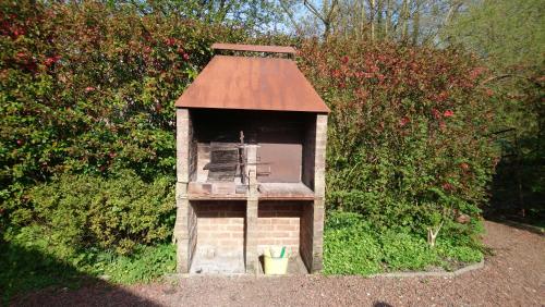 a small brick dog house with a roof at Chalet de vacances in Guisy
