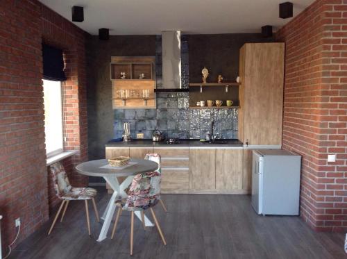 eine Küche mit einem Tisch und Stühlen sowie einem Kühlschrank in der Unterkunft Dream Apartament in Morschyn