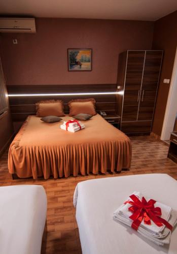 a bedroom with a bed with a red bow on it at Guesthouse Villa Modex in Paraćin