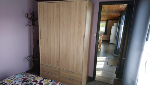 a large wooden cabinet in a bedroom with a bed at Chalet de vacances in Guisy