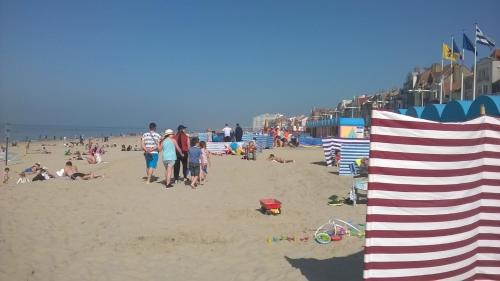 a group of people walking on the beach at Chez Marie in Dunkerque