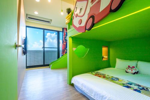 a green room with a bed with a car on the wall at 松楓親子民宿Songfeng Family B&B in Wujie