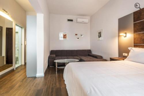 ベオグラードにあるPassion Downtown Suiteのベッドとソファのあるホテルの部屋